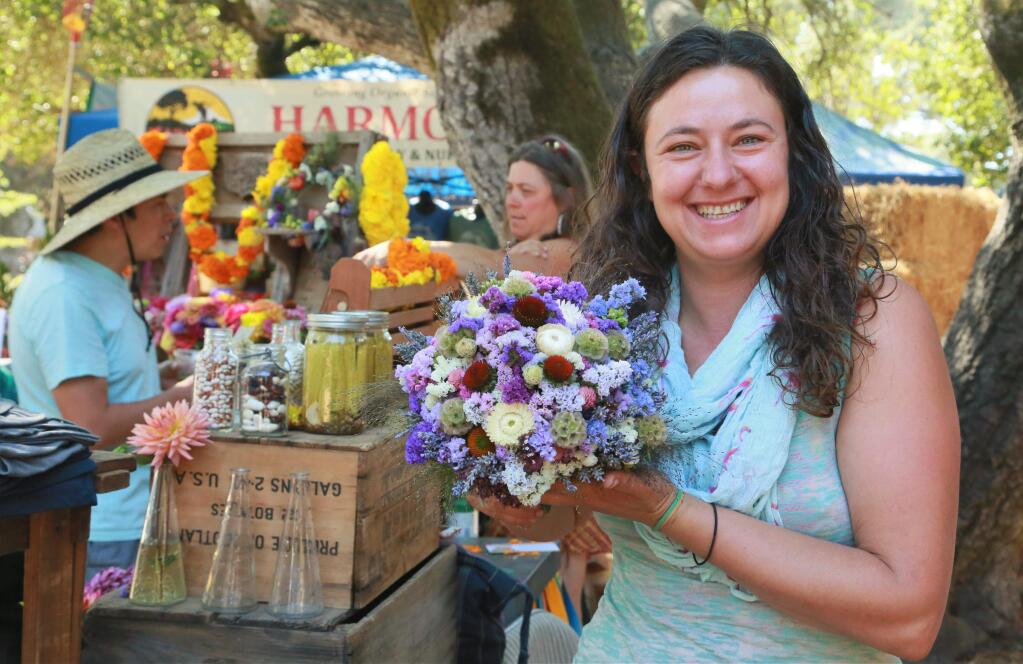 Bree Douma arranges flowers into a bouquet at the 45th Gravenstein Apple Fair at Ragle Ranch Park in Sebastopol, California on Sunday, Aug. 12, 2018. (WILL BUCQUOY/ FOR THE PD)