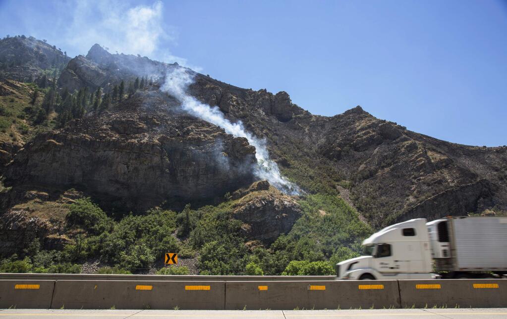 In this July 22, 2014 photo, a wildfire burns in Morgan County, Utah. (AP Photo/Standard-Examiner, Benjamin Zack)