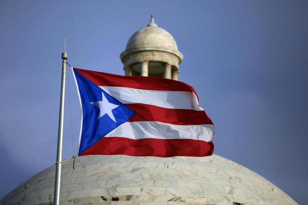 FILE - In this Wednesday, July 29, file 2015 photo, the Puerto Rican flag flies in front of Puerto Ricos Capitol as in San Juan, Puerto Rico. Puerto Rico Gov. Alejandro Javier Garcia Padilla said on Sunday, May 1, 2016, that negotiators for the U.S. territorys government have failed to reach a last-minute deal to avoid a third default and that he has issued an executive order to withhold payment. (AP Photo/Ricardo Arduengo, File)