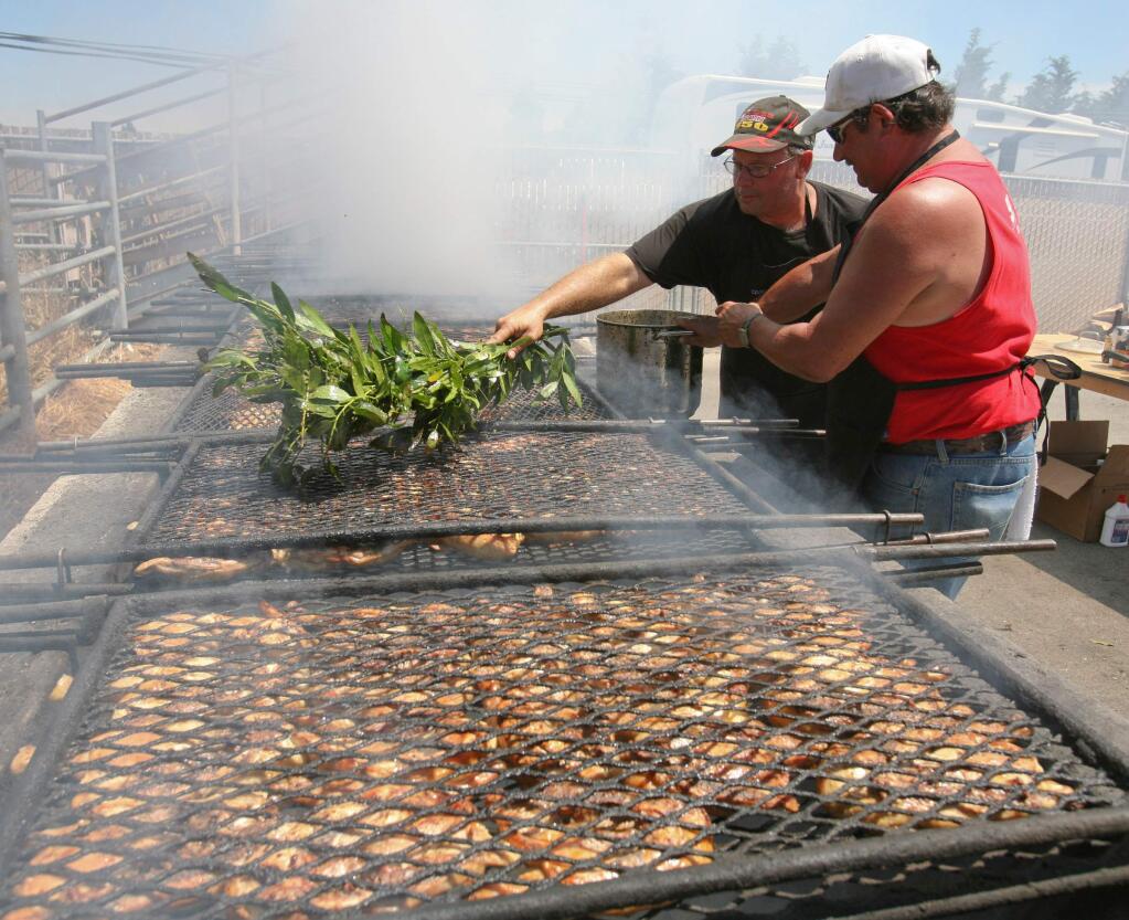 Arnold King, left, and Larry Renshimer baste the chicken at the 48th Annual Wilmar Volunteer Fire Department Chicken BBQ at the Holy Ghost Hall in Petaluma on Sunday July 27, 2014.