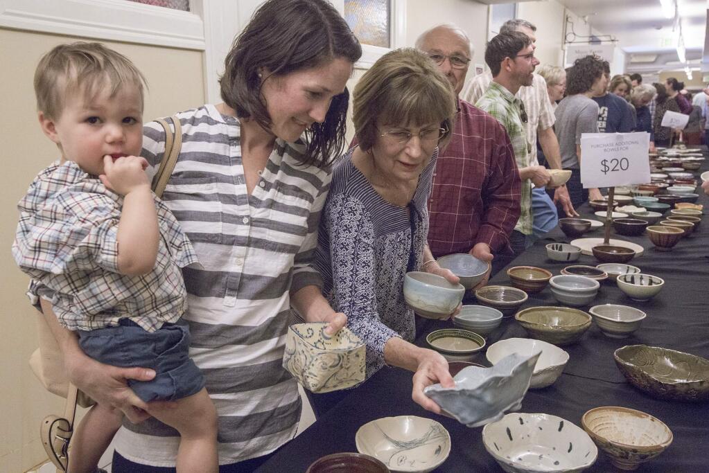 One-year-old Monte Radzik waits patiently while his mother, Amanda, makes her way down a table laden with handmade ceramic bowls. Getting to keep the bowl is part of the charm and draw of this event. After making a choice, attendees at the Sonoma Community Center's annual Chili Bowl could then take their pick from several different kinds of chili, including vegan. The fundraiser for the center took place on Saturday, February 10. (Photo by Robbi Pengelly/Index-Tribune)