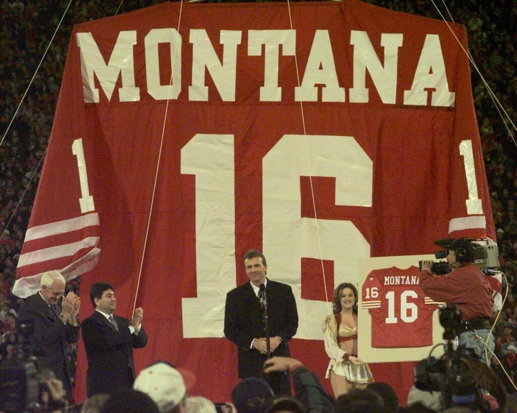 Joe Montana, middle, gets a standing ovation from the crowd as Bill Walsh, left, and Eddie DeBartolo join in during halftime ceremonies retiring the jersey of No. 16.