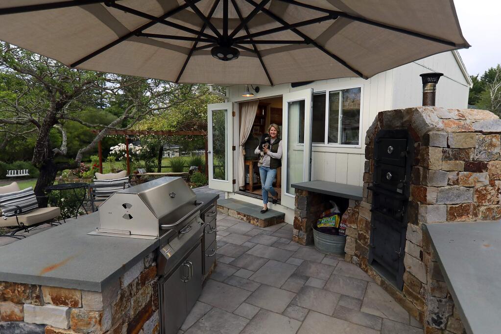 Designer Tama Bell updated the exterior of her 1980's home with new siding, windows, exterior lights and a new outdoor living area with a paved patio, outdoor kitchen, pizza oven and new furniture in a variety of seating nooks. (John Burgess/The Press Democrat)