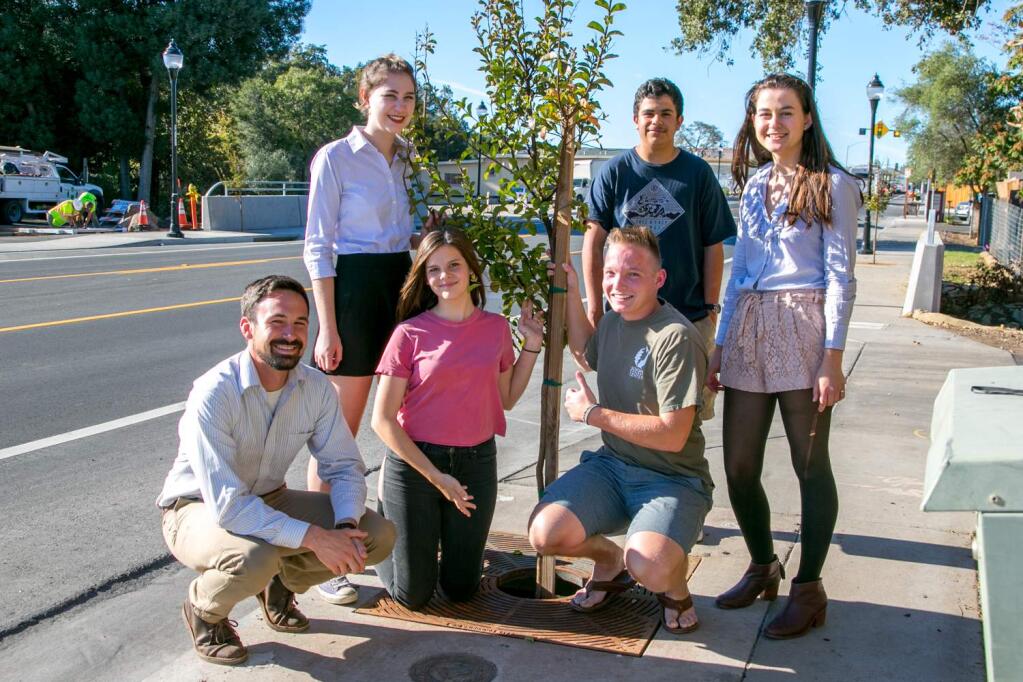 Tony Passantino, left, joins EnviroLeaders along Highway 12 in the Springs. Front row, Naomi Little and Parker Bacon; standing, Sarah Bell, Miguel Fernandez and Emily Webber; at center, tree. (Photo by Julie Vader/Special to the Index-Tribune)