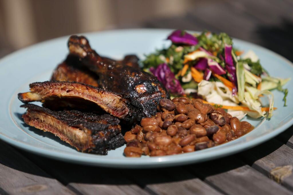 Brannon Fetzer of Q Craft in Sonoma serves up grilled ribs and chicken with a kale slaw and cowboy beans. (Beth Schlanker / The Press Democrat)