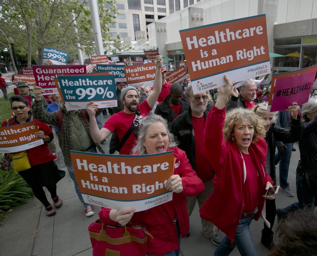 FILE--In this April 26, 2017, file photo, supporters of single-payer health care march to the Capitol in Sacramento, Calif. State experts say a California bill that would provide government-funded health coverage for everyone in the state would cost $400 billion and require significant tax increases. (AP Photo/Rich Pedroncelli, file)