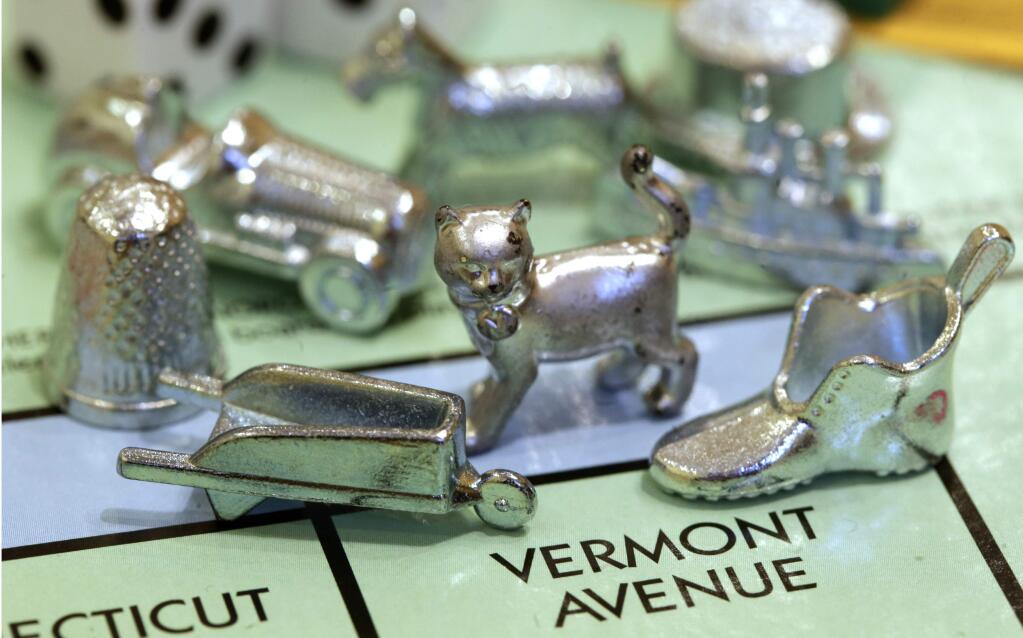 FILE - In this Feb. 5, 2013 file photo, the thimble game piece, left, sits among other Monopoly tokens at Hasbro Inc., headquarters in Pawtucket, R.I. The thimble will no longer be a game piece in Monopoly, rejected in 2017 in a campaign to determine the tokens for the next generation of the game. (AP Photo/Steven Senne, File)