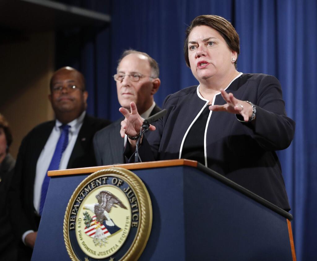 Assistant Attorney General Leslie R. Caldwell, right, of the Criminal Division, with Kenneth Magidson, center, of the Southern District of Texas; and U.S. Treasury Inspector General for Tax Administration J. Russell George, participate in a news conference at the Justice Department in Washington, Thursday, Oct. 27, 2016. Justice Department is announcing charges in connection with a call center operation said to be based in India. Federal prosecutors have unsealed an indictment charging 61 defendants in the United States and abroad, including five call center groups. The department says the extorted funds ended up being laundered with the help of prepaid debit cards. Arrests are taking place throughout the United States. (AP Photo/Pablo Martinez Monsivais)