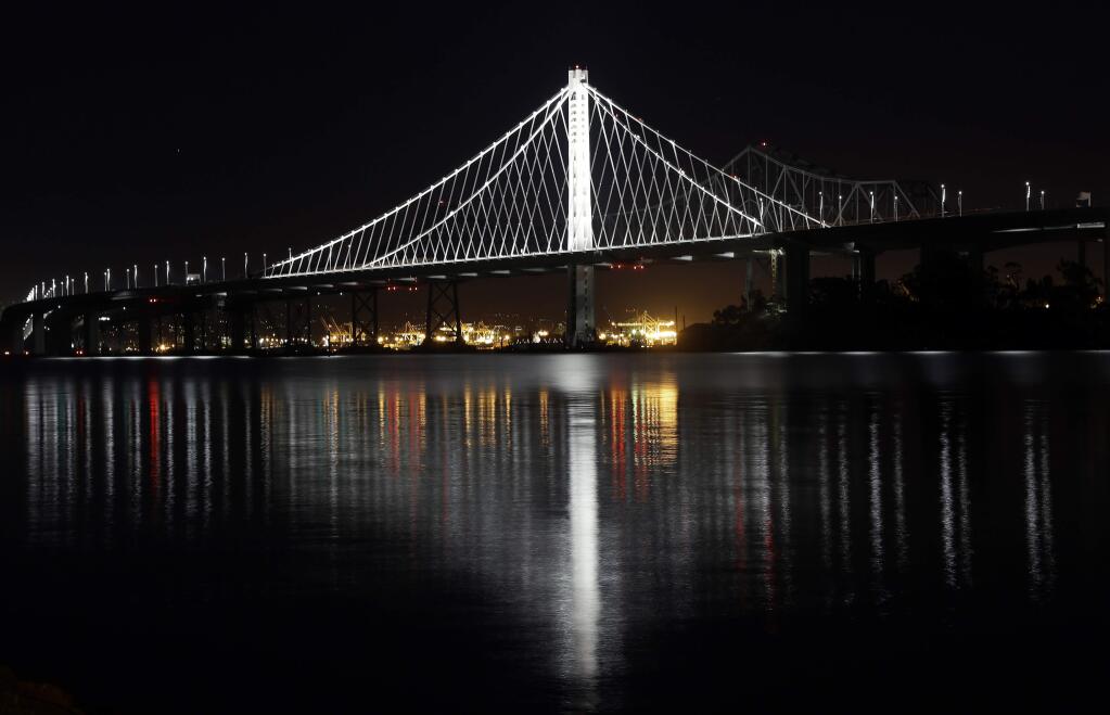 FILE - This Dec. 26, 2013 file photo shows the new eastern span of the San Francisco-Oakland Bay Bridge reflected on the water in a view from Treasure Island in San Francisco. On Thursday, July 24, 2014, Marwan Nader, the chief designer of the new span told bridge oversight officials at a meeting that more than 2,000 bolts and rods on the span do not need to be replaced after 32 other bolts cracked when they were tightened last year. (AP Photo/Marcio Jose Sanchez, file)