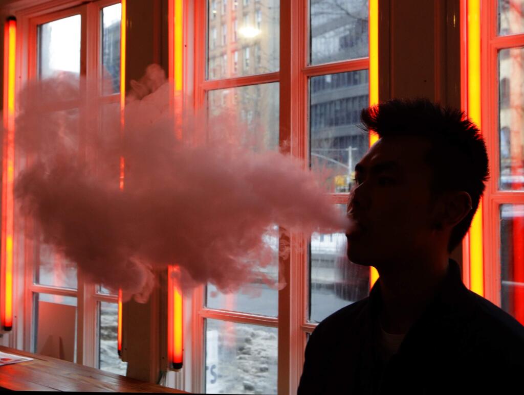 FILE - In this Feb. 20, 2014 file photo, a man exhales vapor from an e-cigarette in New York. (AP Photo/Frank Franklin II)