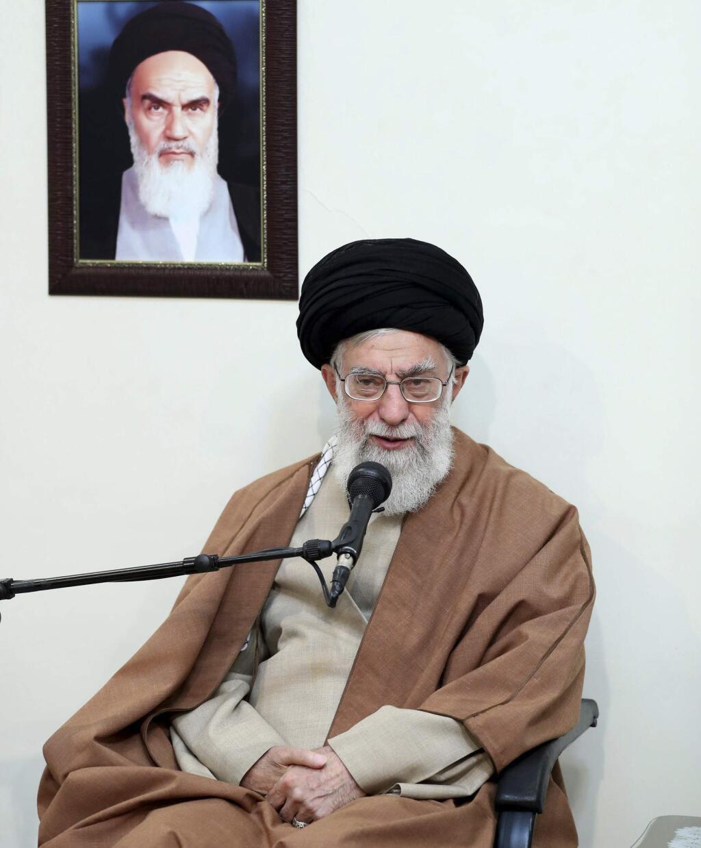 In this picture released by official website of the office of the Iranian supreme leader, Supreme Leader Ayatollah Ali Khamenei speaks in a meeting as he sits under a portrait of the late Iranian revolutionary founder Ayatollah Khomeini, in Tehran, Iran, Tuesday, Jan. 2, 2018. Khamenei said Tuesday that the country's enemies have meddled in recent protest rallies. The report on the website of Ayatollah Ali Khamenei quoted him as saying “in recent days” enemies of Iran have utilized various means including money, weapons, politics and intelligence apparatuses. (Office of the Iranian Supreme Leader via AP)