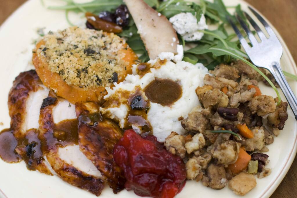 FILE- This Oct. 8, 2012, file photo shows a Thanksgiving dinner plate of cider brined turkey with sage gravy, peach cranberry sauce, sour cream and chive mashed potatoes, sausage pecan stuffing, arugula pear salad with pomegranate vinaigrette and goat cheese and herb crusted sweet potatoes in Concord, N.H. (AP Photo/Matthew Mead, File)