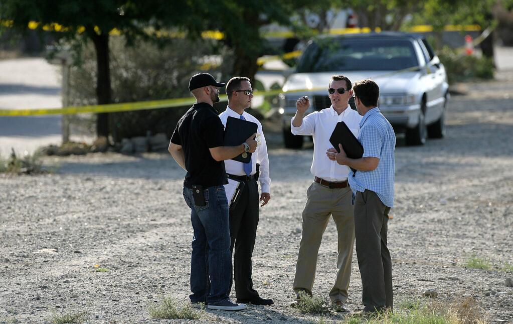 Law enforcement officers work at a crime scene, where two people were fatally shot, in Banning, Calif., on Saturday, Sept. 26, 2015. The driver and passenger in a red car were shot, killing the driver and injuring the passenger, in a random shooting spree on Saturday. (Random Deadly Shootings/The Press-Enterprise via AP)