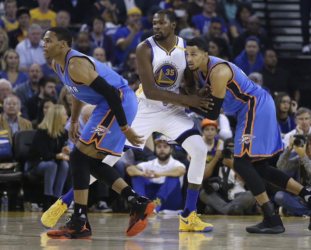 Oklahoma City Thunder guard Russell Westbrook, left, and Andre Roberson, right, guard Golden State Warriors' Kevin Durant (35) during the first half of an NBA basketball game Thursday, Nov. 3, 2016, in Oakland, Calif. (AP Photo/Ben Margot)