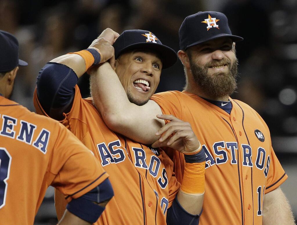 Houston Astros' Carlos Gomez, left, and Evan Gattis joke around during player introductions before the start of the American League wild card baseball game against the New York Yankees, Tuesday, Oct. 6, 2015, in New York. (AP Photo/Julie Jacobson)