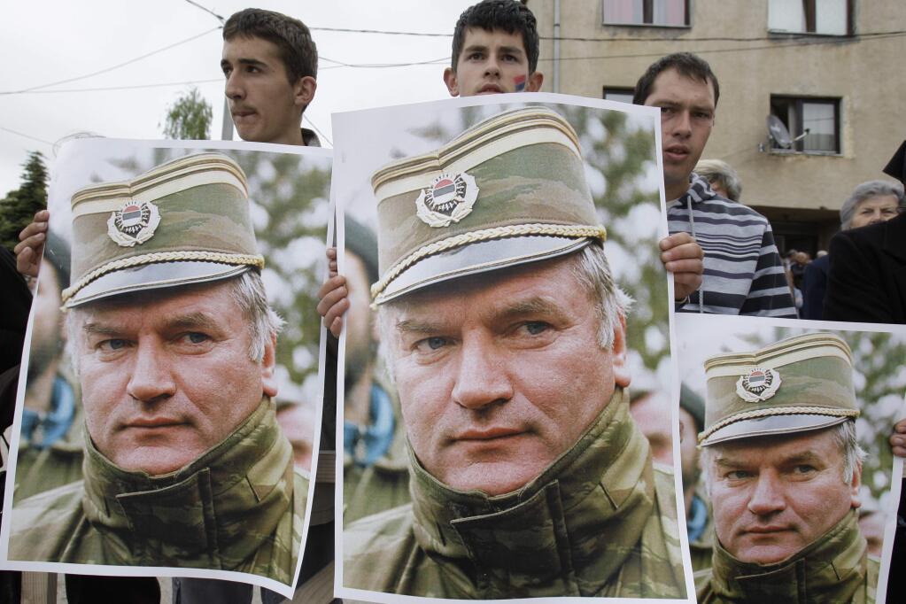 FILE - A May 29, 2011 file photo shows Bosnian Serb protesters holding posters depicting former Bosnian Serb army chief Ratko Mladic, during a protest in Mladic's hometown of Kalinovik, Bosnia-Herzegovina. (AP Photo/Amel Emric, File)