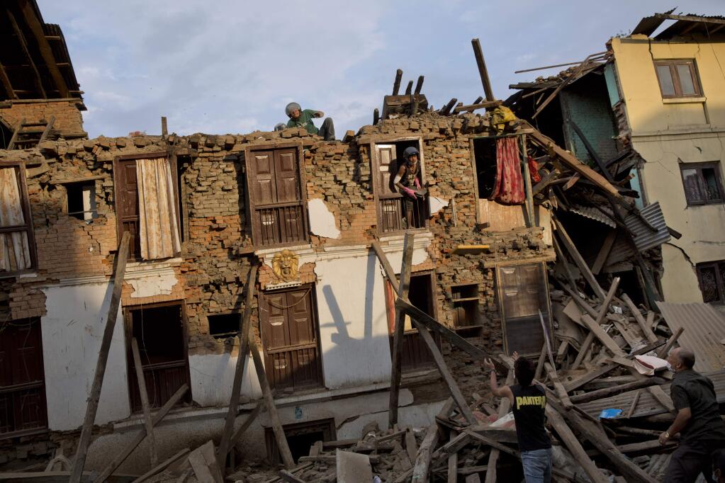 Nepalese villagers salvage items from a house destroyed by Saturday's earthquake in Sakhu, on the outskirts of Kathmandu, Nepal, Wednesday, April 29, 2015. The 7.8 magnitude earthquake shook Nepals capital and the densely populated Kathmandu valley on Saturday devastating the region and leaving tens of thousands shell-shocked and sleeping in streets. (AP Photo/Bernat Amangue)