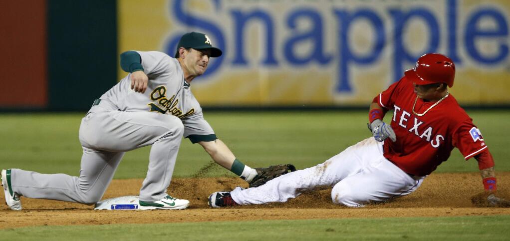Oakland Athletics second baseman Nick Punto, left, tags out a stealing Texas Rangers' Elvis Andrus, right, during the fifth inning of a baseball game, Saturday, Sept. 27, 2014, in Arlington, Texas. (AP Photo/John F. Rhodes)