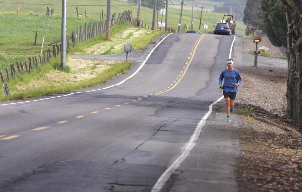 Paul Braa of Petaluma runs along Corona Road which is a patchwork of repairs over the years on Monday, March 23, 2015. (SCOTT MANCHESTER/ARGUS-COURIER STAFF)