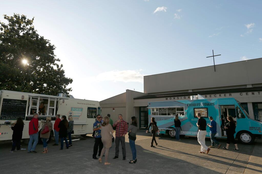 Guests order food from the Fork Catering and Croques and Toques food trucks during the iDrink 4 iPads fundraiser for St. Eugene's Cathedral School Friday, May 20, 2016. (Alvin Jornada / The Press Democrat)