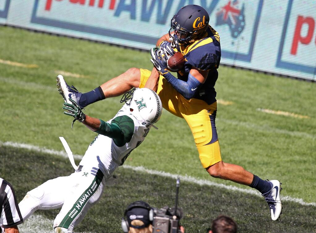 California Golden Bears' Chad Hansen, right, catches a touchdown pass over Hawaii Rainbow Warriors' Jalen Rogers during the opening game of the U.S. college football season at Sydney's Olympic stadium in Sydney, Saturday, Aug. 27, 2016. The last American football of any kind played in Sydney was an NFL preseason game at the Olympic stadium that attracted 73,000 spectators in 1999. (AP Photo/Rick Rycroft)