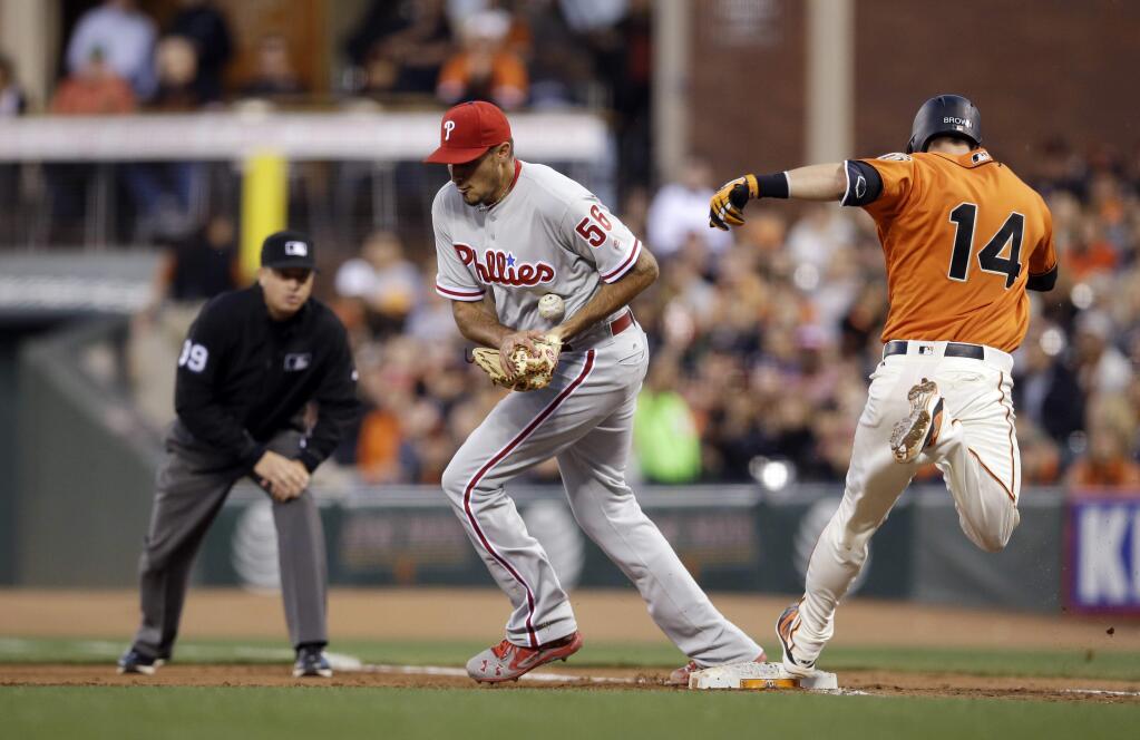 San Francisco Giants' Trevor Brown (14) is safe at first base on a throwing error from Philadelphia Phillies first baseman Ryan Howard to starting pitcher Zach Eflin (56) during the fourth inning of a baseball game Friday, June 24, 2016, in San Francisco. (AP Photo/Marcio Jose Sanchez)