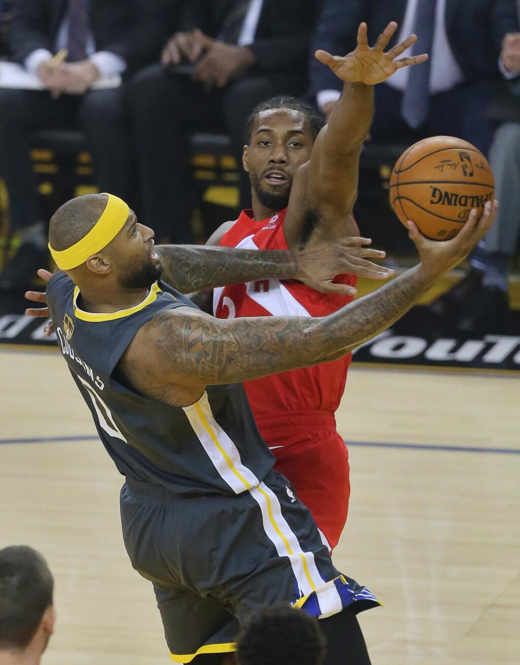 Golden State Warriors center DeMarcus Cousins lays the ball up against Toronto Raptors forward Kawhi Leonard during game 4 of the NBA Finals in Oakland on Friday, June 7, 2019. (Christopher Chung/ The Press Democrat)