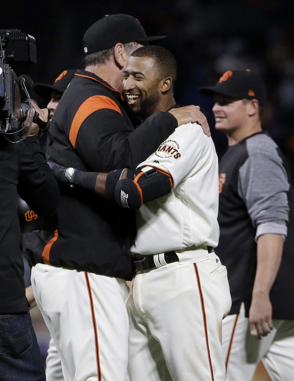 San Francisco Giants' Eduardo Nunez, front right, hugs manager Bruce Bochy after singling to score Kelby Tomlinson for the winning run during the 10th inning of a baseball game against the Cleveland Indians in San Francisco, Tuesday, July 18, 2017. The Giants won 2-1. (AP Photo/Jeff Chiu)