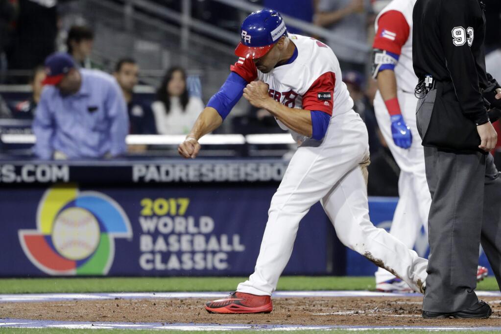 Puerto Rico's Angel Pagan reacts after scoring off a single by Carlos Correa during the first inning of a second-round World Baseball Classic game against the United States on Friday, March 17, 2017, in San Diego. (AP Photo/Gregory Bull)