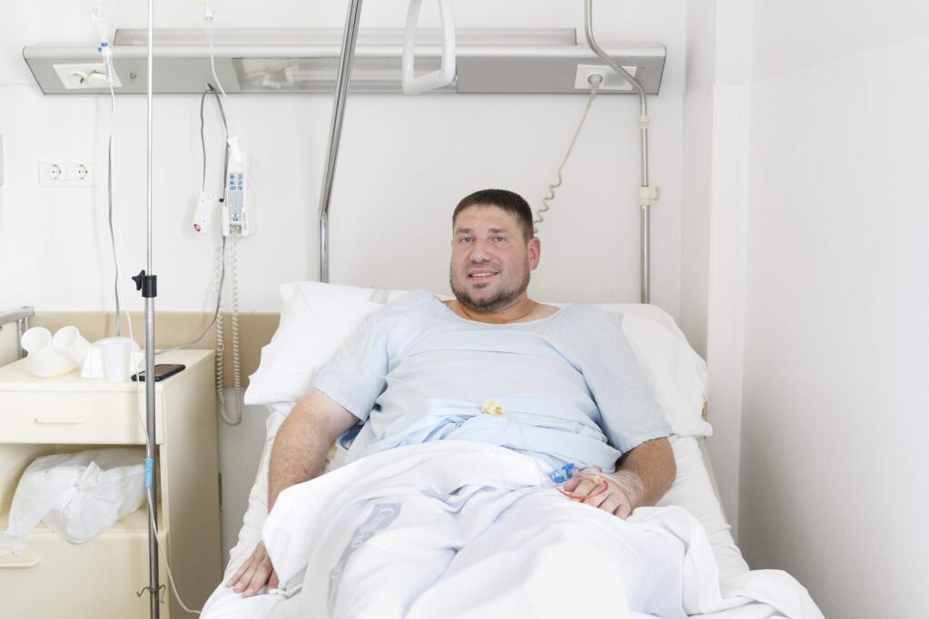 Mike Webster, a 38-year-old occupational therapist from Gainesville, Florida, who was gored in the armpit while running with the bulls in Pamplona for the 38th time over the last 11 years, poses for a picture on his hospital bed in Pamplona, Spain, Tuesday, July 7, 2015. Two Americans and a Briton were gored and eight others injured Tuesday as thousands of daredevils dashed alongside fighting bulls through the streets of this northern Spanish city on the first bull run of the San Fermin festival (AP Photo/Daniel Ochoa de Olza)