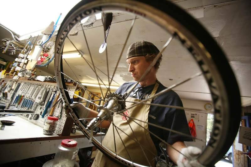 Community Bikes volunteer Michael Garrison fixes a bicycle wheel at their shop off Sebastopol Road in Santa Rosa on Thursday, July 25, 2013. (Conner Jay / The Press Democrat)