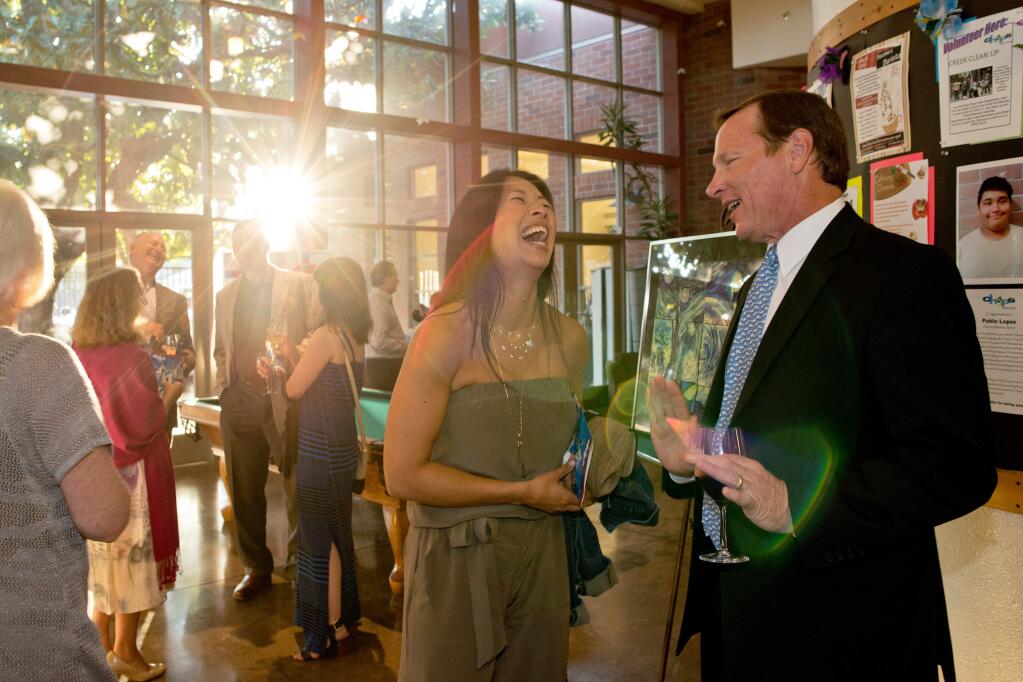 Santa Rosa City Council candidate Tom Schwedhelm, right, talks with Mishel Kaufman of Redwood Credit Union during Chop's Teen Club's Back to the Future fundraising event, in Santa Rosa on Sept. 13, 2014. (Alvin Jornada / For The Press Democrat)