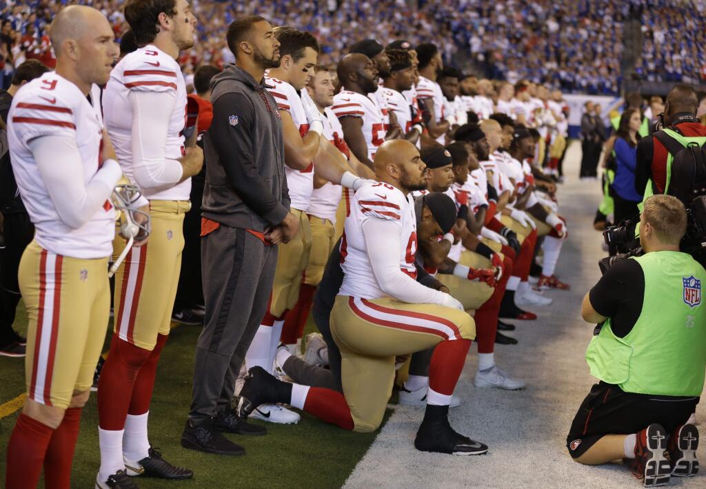 Members of the San Francisco 49ers kneel during the playing of the national anthem before a game against the Indianapolis Colts, Sunday, Oct. 8, 2017, in Indianapolis. Vice President Mike Pence left the game after about a dozen San Francisco players took a knee. (AP Photo/Michael Conroy)