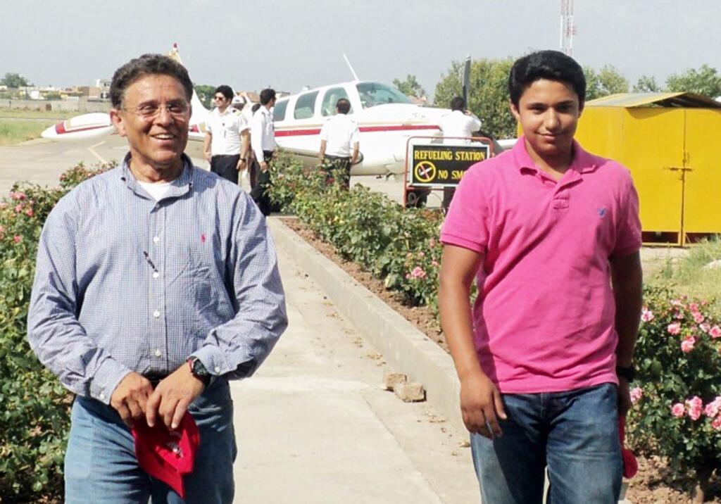 In this July 2014 photo provided by The Citizens Foundation 17-year-old Haris Suleman and his father Babar Suleman, 58, walk away from their single-engine airplane at a stop Islamabad, Pakistan, on their around-the-world flight. The body of the Plainfield, Indiana, teen was recovered after the plane crashed Tuesday, July 22, 2014 shortly after taking off from Pago Pago in American Samoa. Crews were still searching for Babar Suleman. (AP Photo/Courtesy The Citizens Foundation)