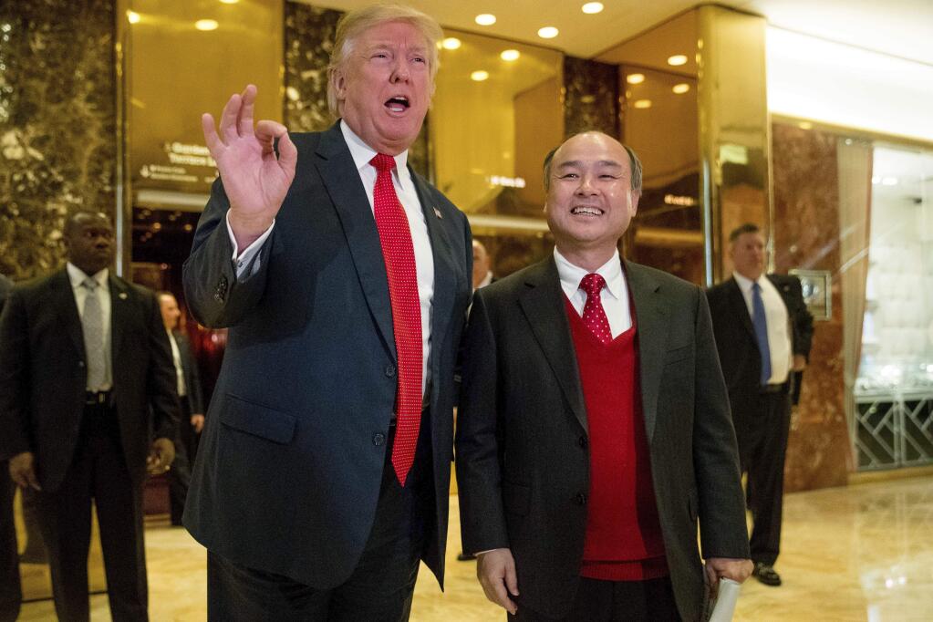 President-elect Donald Trump, accompanied by SoftBank CEO Masayoshi Son, speaks to members of the media at Trump Tower in New York, Tuesday, Dec. 6, 2016. (AP Photo/Andrew Harnik)