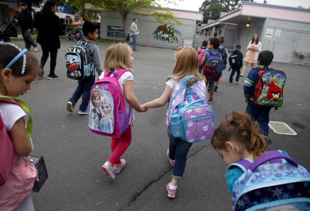 Friends Elizabeth Lemenager, 5, left, and Abigail Evans, 5, hold hands as they walk together on the first day of kindergarten at Mattie Washburn Elementary School in Windsor, on Thursday, August 13, 2015. (BETH SCHLANKER/ The Press Democrat)