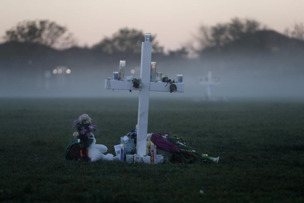 An early morning fog rises where 17 memorial crosses were placed, for the 17 deceased students and faculty from the Wednesday shooting at Marjory Stoneman Douglas High School, in Parkland, Fla., Saturday, Feb. 17, 2018. As families began burying their dead, authorities questioned whether they could have prevented the attack at the high school where a gunman, Nikolas Cruz, took several lives. (AP Photo/Gerald Herbert)