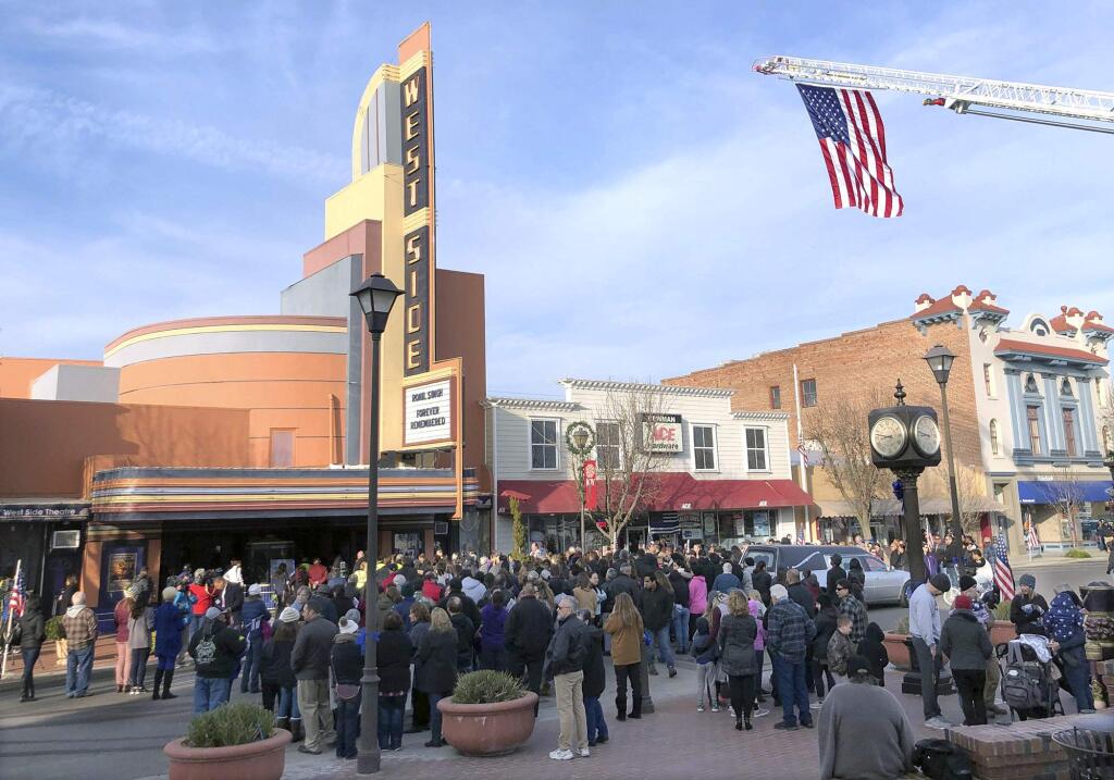 People gather outside the West Side Theatre into the Westside Theatre for the public viewing of Newman Police Cpl. Ronil Singh, Friday, Jan. 4, 2019, in Newman, Calif. Prosecutors on Wednesday, Jan. 2, charged Gustavo Perez Arriaga in Singh's killing. Perez Arriaga, who was in the country illegally, was arrested after a dayslong manhunt as he prepared to flee to Mexico, authorities said. (Deke Farrow/The Modesto Bee via AP)