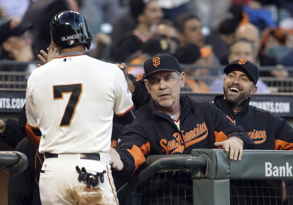 San Francisco Giants' Gregor Blanco (7) is welcomed to the dugout by manager Bruce Bochy, center, after Blanco scored against the Arizona Diamondbacks in the first inning of a baseball game against the Arizona Diamondbacks Thursday, April 16, 2015, in San Francisco. Blanco scored on a single hit by Giants' Buster Posey. (AP Photo/Ben Margot)