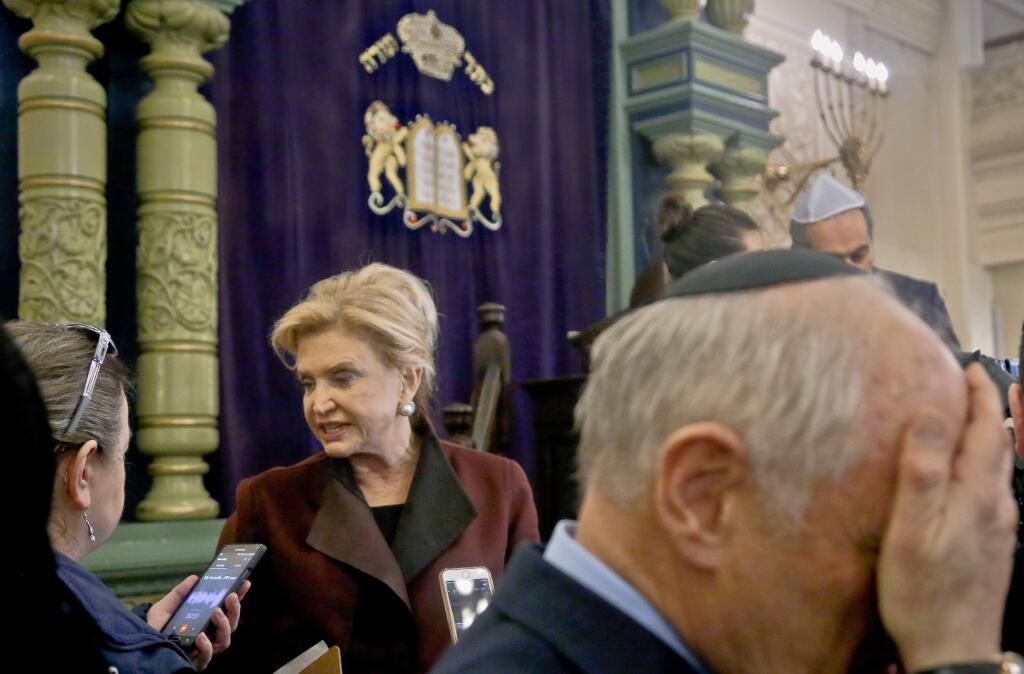 FILE - In this March 3, 2017, file photo, Congresswoman Carolyn Maloney, center, a member of Congress's bipartisan task force combating anti-Semitism, speaks with a reporter after holding a press conference to address bomb treats against Jewish organizations and vandalism at Jewish cemeteries at the Park East Synagogue in New York. Israeli police arrested a 19-year-old Israeli Jewish man on Thursday, March 23, as the primary suspect in a string of bomb threats targeting Jewish community centers and other institutions in the U.S., marking a potential breakthrough in the case. (AP Photo/Bebeto Matthews, File)