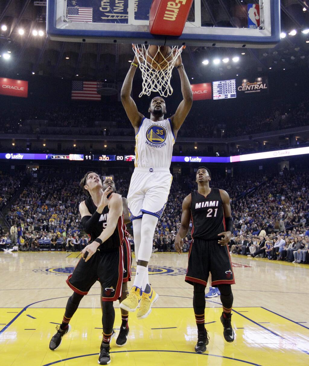 Golden State Warriors' Kevin Durant (35) dunks past Miami Heat's Luke Babbitt, left, and Hassan Whiteside (21) during the first half of an NBA basketball game Tuesday, Jan. 10, 2017, in Oakland, Calif. (AP Photo/Marcio Jose Sanchez)
