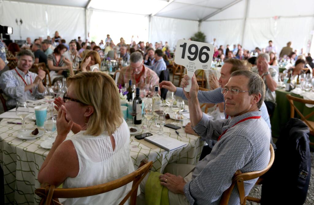 Proxy, Limeng Stroh bidding for Glenn Knight, won a lot with a bid of $24,000 during the during the Sonoma County Barrel Auction held at the Vintners Inn in Santa Rosa , Friday, May 1, 2015. (CRISTA JEREMIASON / The Press Democrat)