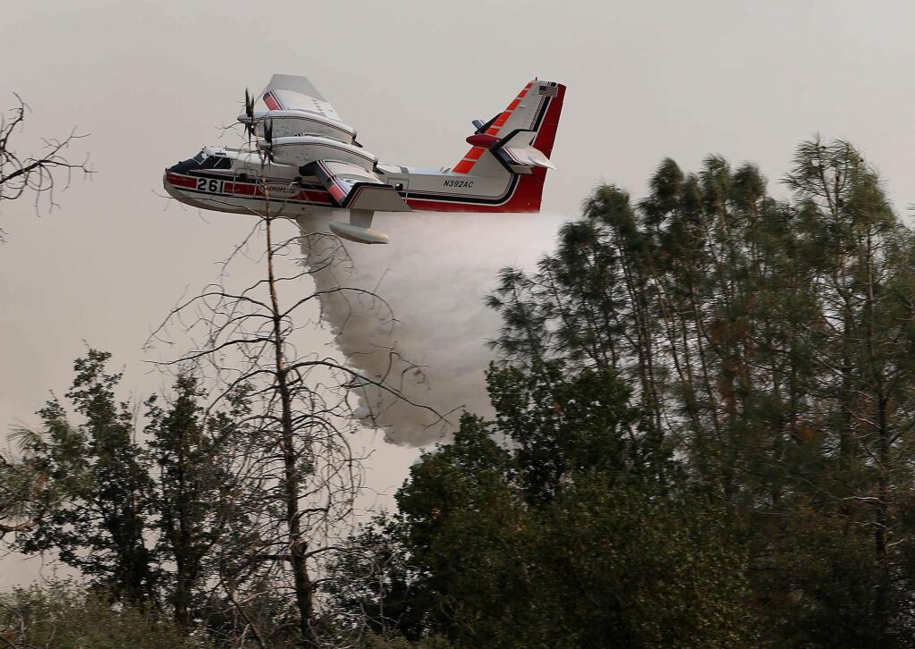 An airplane makes a water drop on the Havilah, Calif., fire Saturday, Aug. 27, 2016 in this mountainous community east of Bakersfield, Calif., (Casey Christie/The Bakersfield Californian via AP)