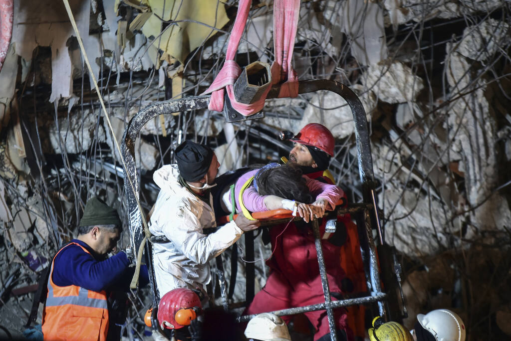 Rescuers pull out a woman from a collapsed building 87 hours after the earthquake in Kahramanmaras, southern Turkey, Thursday, Feb. 9, 2023. ( IHA via AP)