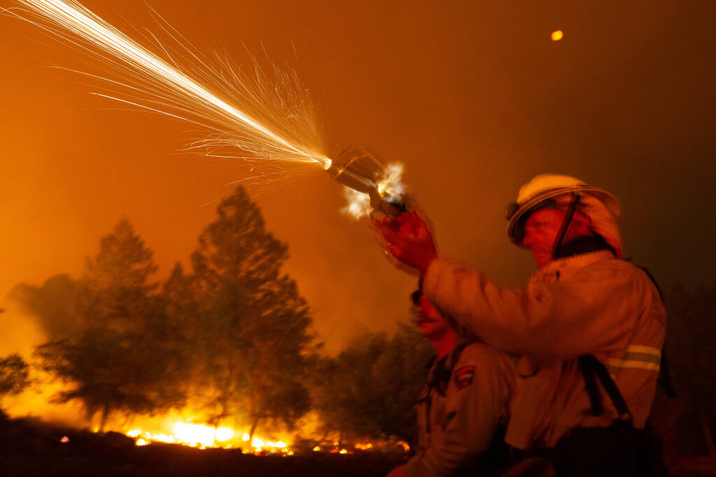 A flare gun recoils as San Bruno Fire Department battalion chief Bill Forester shoots a flare into dense vegetation during a defensive firing operation at Sugarloaf Ridge State Park to create a buffer between the head of the Glass fire and adjacent communities near Kenwood, California, on Tuesday, September 29, 2020. Forester was part of a crew assigned to fight the Glass fire. (Alvin A.H. Jornada / The Press Democrat)
