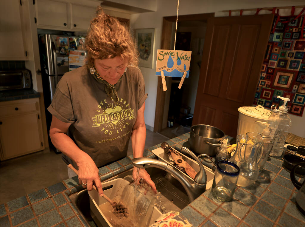 Brigitte Mansell recycles all of her dishwater  to water her yard plants, Tuesday, June 16, 2021 in Healdsburg. (Kent Porter / The Press Democrat) 2021