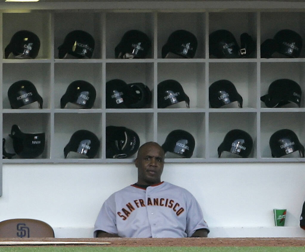 The San Francisco Giants’ Barry Bonds sits in the dugout before the start of a ame against the Padres in San Diego on Friday Aug. 3, 2007. (Lenny Ignelzi / ASSOCIATED PRESS)