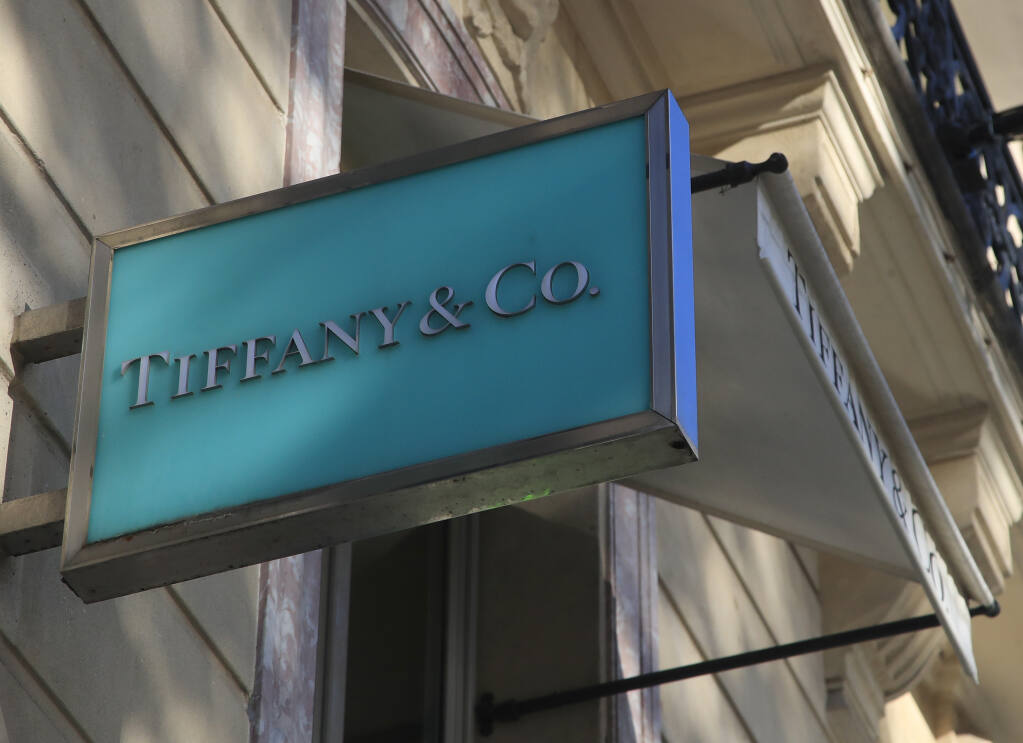 FILE - In this Nov. 25, 2019 file photo, the logo of Tiffany & Co. is pictured on the Champs Elysees avenue in Paris. Luxury goods giant LVMH is ending its takeover deal of the luxury jewelry retailer, citing in part the threat of proposed U.S. tariffs on French goods. (AP Photo/Michel Euler, File)