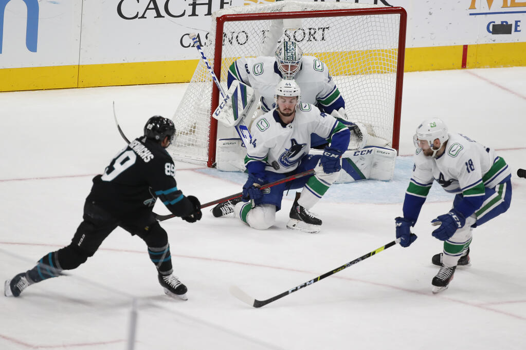 Vancouver Canucks defenseman Kyle Burroughs makes a save against San Jose Sharks left wing Jayden Halbgewachs during the first period on Thursday, Dec. 16, 2021, in San Jose. (Josie Lepe / ASSOCIATED PRESS)
