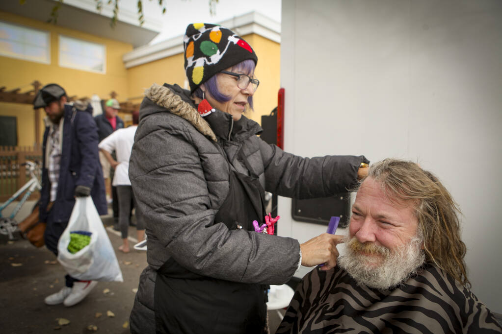 Bridget Maier, a hairdresser from Clearlake, volunteered to give haircuts and shaves at COTS on Friday, December 23, 2022, while the Downtown Streets Team’s mobile showers were parked and available there. Philip McLoughlin asked for a shave. (CRISSY PASCUAL/ARGUS-COURIER STAFF)